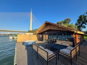 Splav na dan Kairo - proslave do 25 gostiju. Savršen prostor za sve vrste okupljanja. Fotografija prikazuje terasu splava na kome se nalazi garnitura za sedenje, đakuzi, ležaljke.